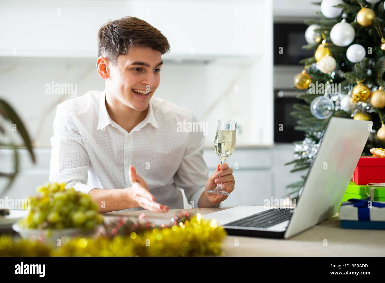 homme communique joyeusement par appel vidéo le soir du nouvel an Banque D'Images