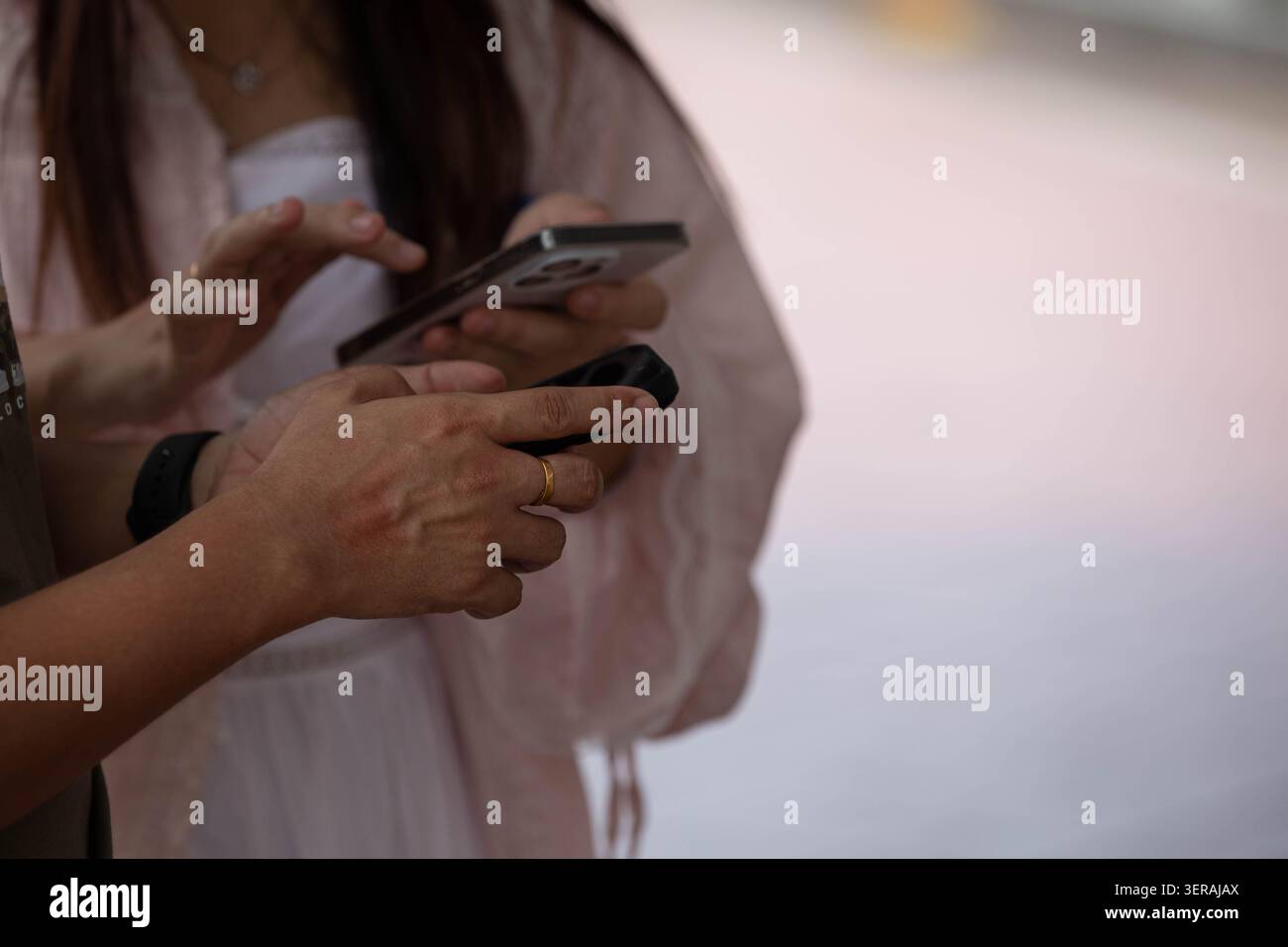 Homme et femme utilisant des smartphones ensemble, gros plan. Banque D'Images
