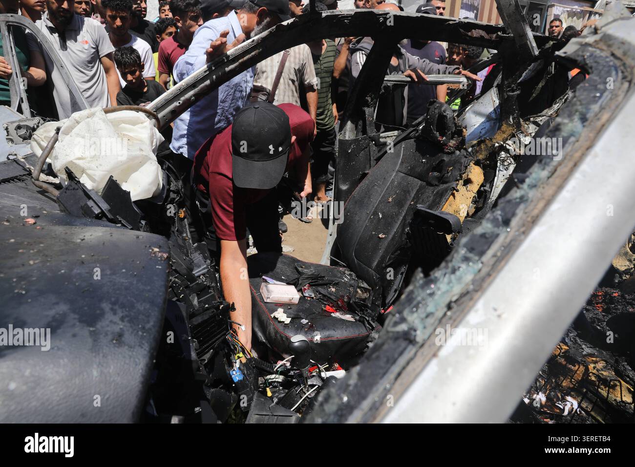 Les Palestiniens se rassemblent sur le site de la grève meurtrière de véhicules dans la ville de Gaza les Palestiniens et le personnel de la défense civile se rassemblent autour d’un véhicule détruit qui a été pris pour cible lors d’une frappe aérienne israélienne dans la ville de Gaza, le 18 juin 2026. La frappe a tué trois Palestiniens, selon des sources médicales, et a causé d'importants dégâts au véhicule. Photo de Belal Osama apaimages Gaza bande de Gaza territoire palestinien 180626_Gaza_BO_1_0033 Copyright : xapaimagesxBelalxOsamaxxapaimagesx Banque D'Images