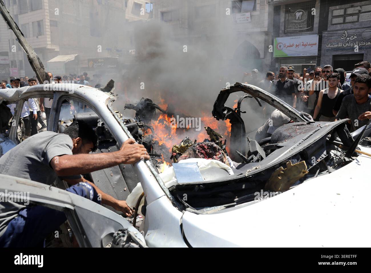 Les Palestiniens se rassemblent sur le site de la grève meurtrière de véhicules dans la ville de Gaza les Palestiniens et le personnel de la défense civile se rassemblent autour d’un véhicule détruit qui a été pris pour cible lors d’une frappe aérienne israélienne dans la ville de Gaza, le 18 juin 2026. La frappe a tué trois Palestiniens, selon des sources médicales, et a causé d'importants dégâts au véhicule. Photo de Belal Osama apaimages Gaza bande de Gaza territoire palestinien 180626_Gaza_BO_1_009 Copyright : xapaimagesxBelalxOsamaxxapaimagesx Banque D'Images