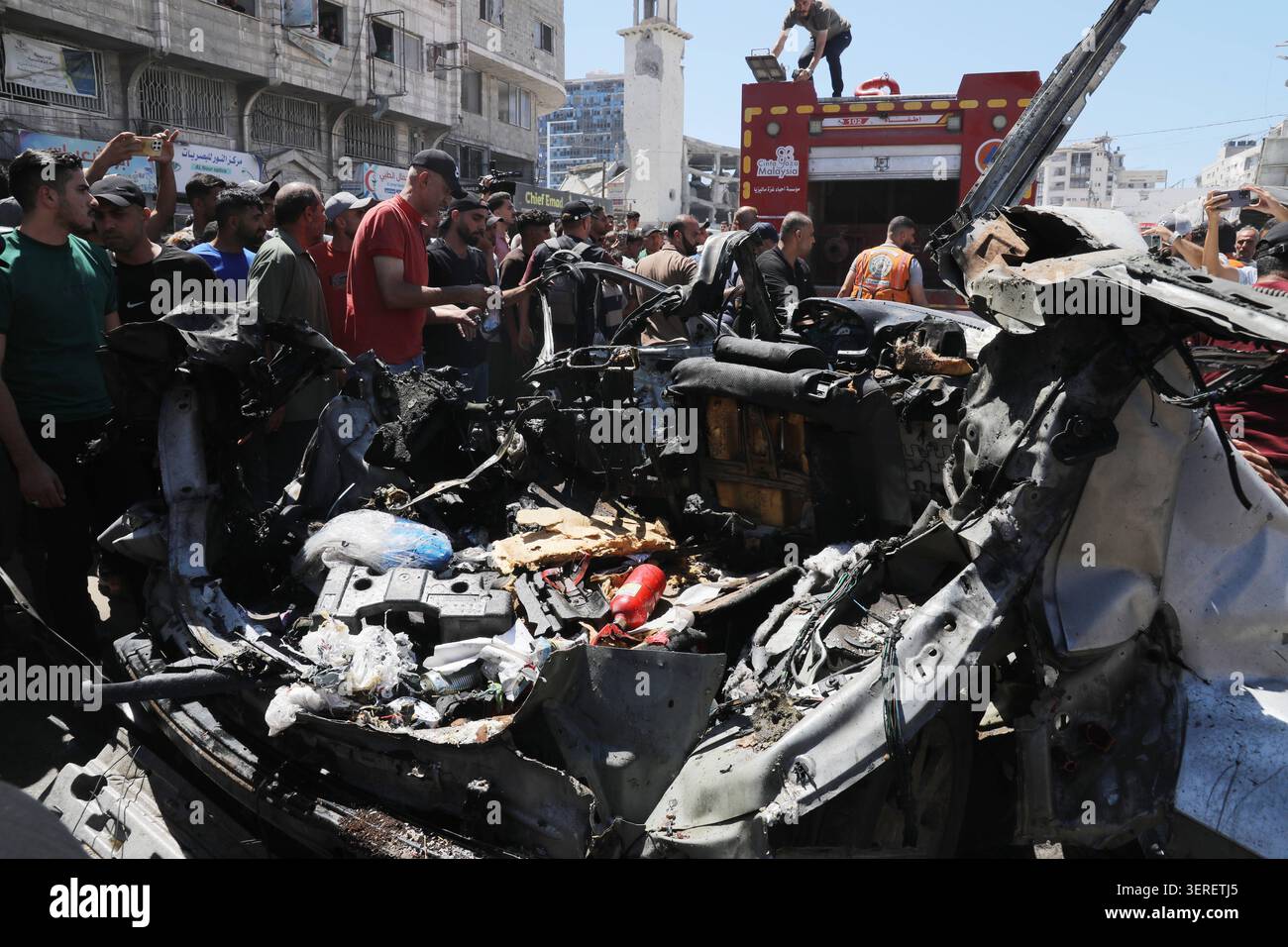 Les Palestiniens se rassemblent sur le site de la grève meurtrière de véhicules dans la ville de Gaza les Palestiniens et le personnel de la défense civile se rassemblent autour d’un véhicule détruit qui a été pris pour cible lors d’une frappe aérienne israélienne dans la ville de Gaza, le 18 juin 2026. La frappe a tué trois Palestiniens, selon des sources médicales, et a causé d'importants dégâts au véhicule. Photo de Belal Osama apaimages Gaza bande de Gaza territoire palestinien 180626_Gaza_BO_1_0041 Copyright : xapaimagesxBelalxOsamaxxapaimagesx Banque D'Images