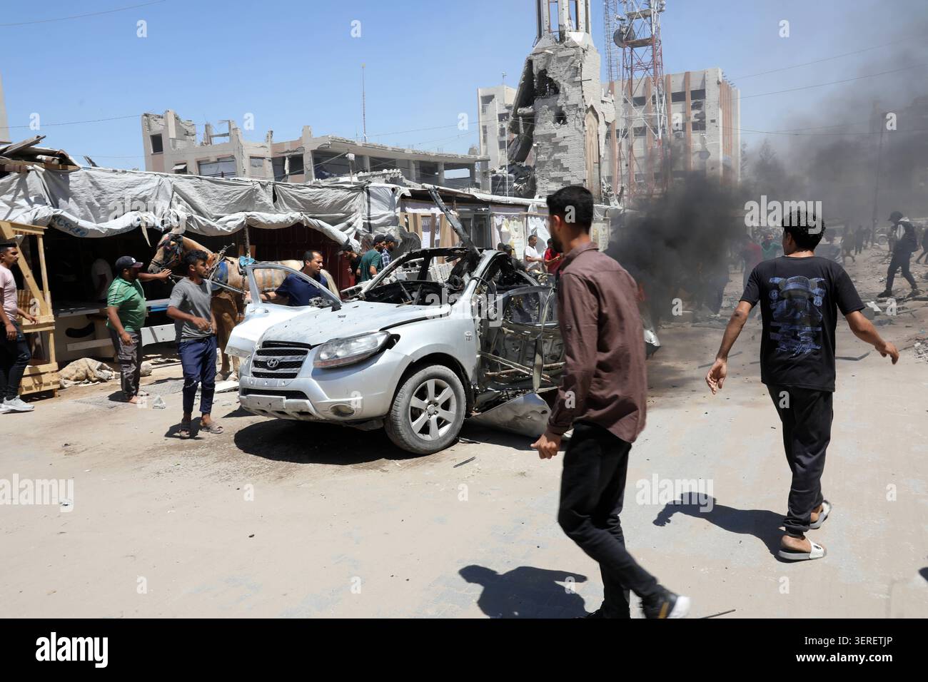 Les Palestiniens se rassemblent sur le site de la grève meurtrière de véhicules dans la ville de Gaza les Palestiniens et le personnel de la défense civile se rassemblent autour d’un véhicule détruit qui a été pris pour cible lors d’une frappe aérienne israélienne dans la ville de Gaza, le 18 juin 2026. La frappe a tué trois Palestiniens, selon des sources médicales, et a causé d'importants dégâts au véhicule. Photo de Belal Osama apaimages Gaza bande de Gaza territoire palestinien 180626_Gaza_BO_1_005 Copyright : xapaimagesxBelalxOsamaxxapaimagesx Banque D'Images