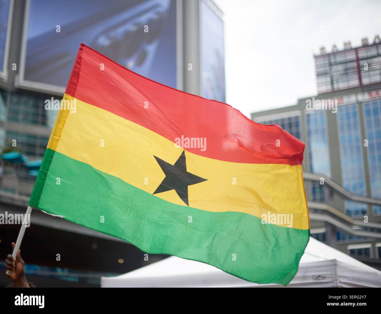 Une main agitant le Ghanian flag.Sky Banque D'Images