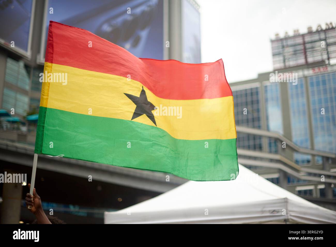 Une main agitant le Ghanian flag.Sky Banque D'Images