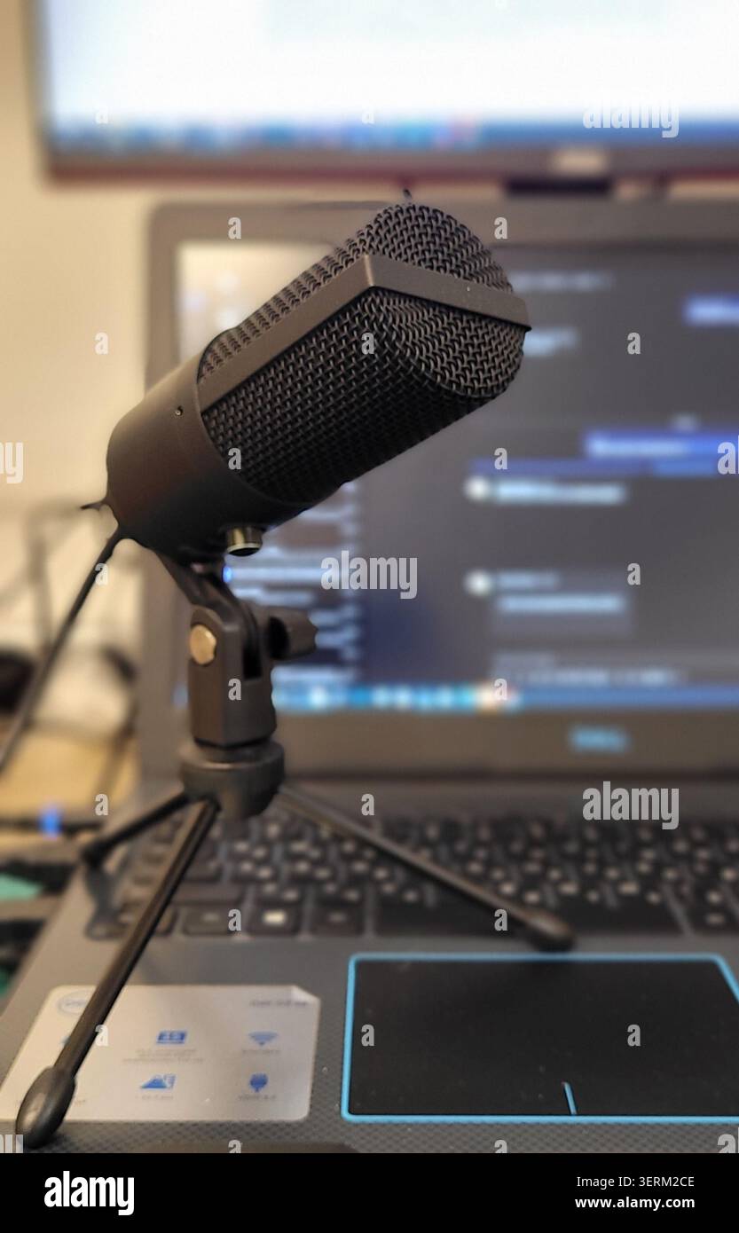 Un microphone professionnel avec filtres pop est installé devant un ordinateur portable. La configuration suggère de se concentrer sur l'enregistrement audio, éventuellement pour des tâches Banque D'Images
