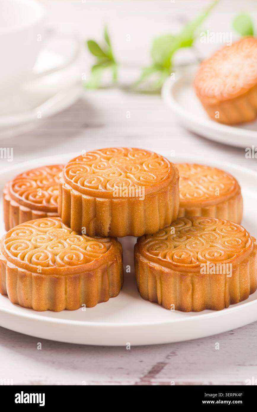 Gâteaux de lune traditionnels aux motifs complexes présentés sur une assiette blanche Banque D'Images