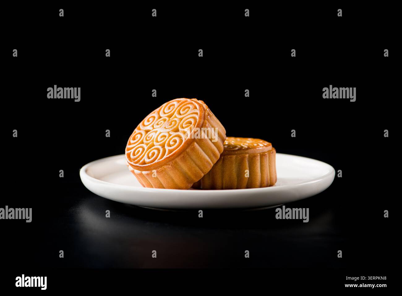 Gâteaux de lune dorés reposant sur un fond sombre pour la célébration du festival de mi-automne Banque D'Images