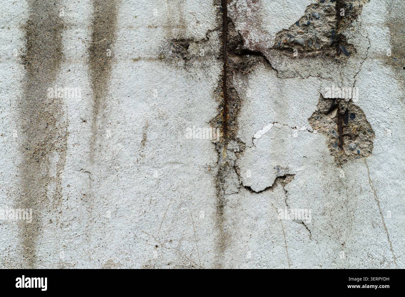 Surface de béton détériorée avec barre d'armature exposée Banque D'Images