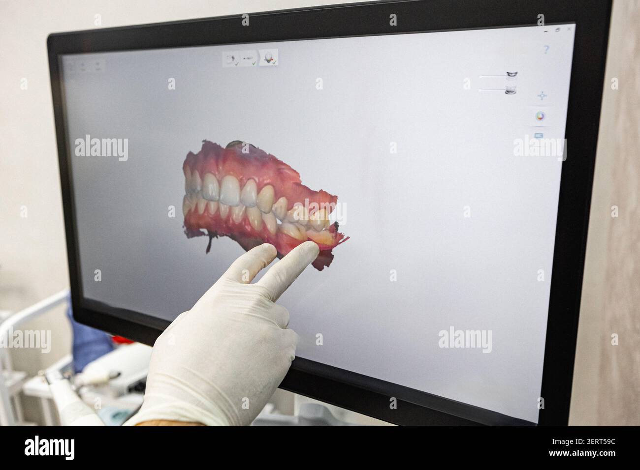 Dentiste pointant le modèle dentaire 3D sur écran d'ordinateur dans la clinique moderne Banque D'Images