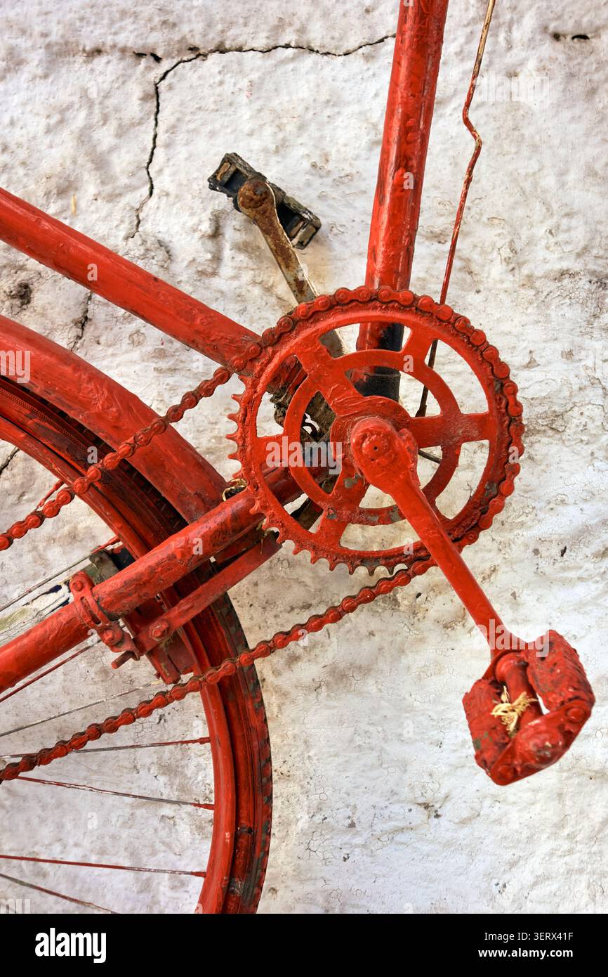 Pédales de vélo rouges contre un mur blanc. Banque D'Images