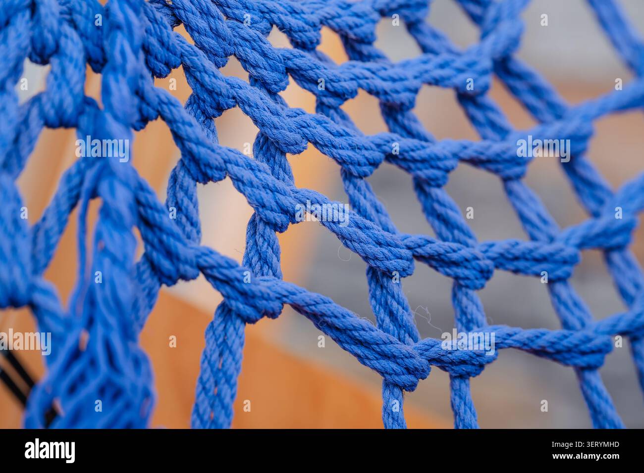 Gros plan d'un filet de corde bleu étroitement tissé avec des cordes tressées épaisses et des jonctions nouées Banque D'Images