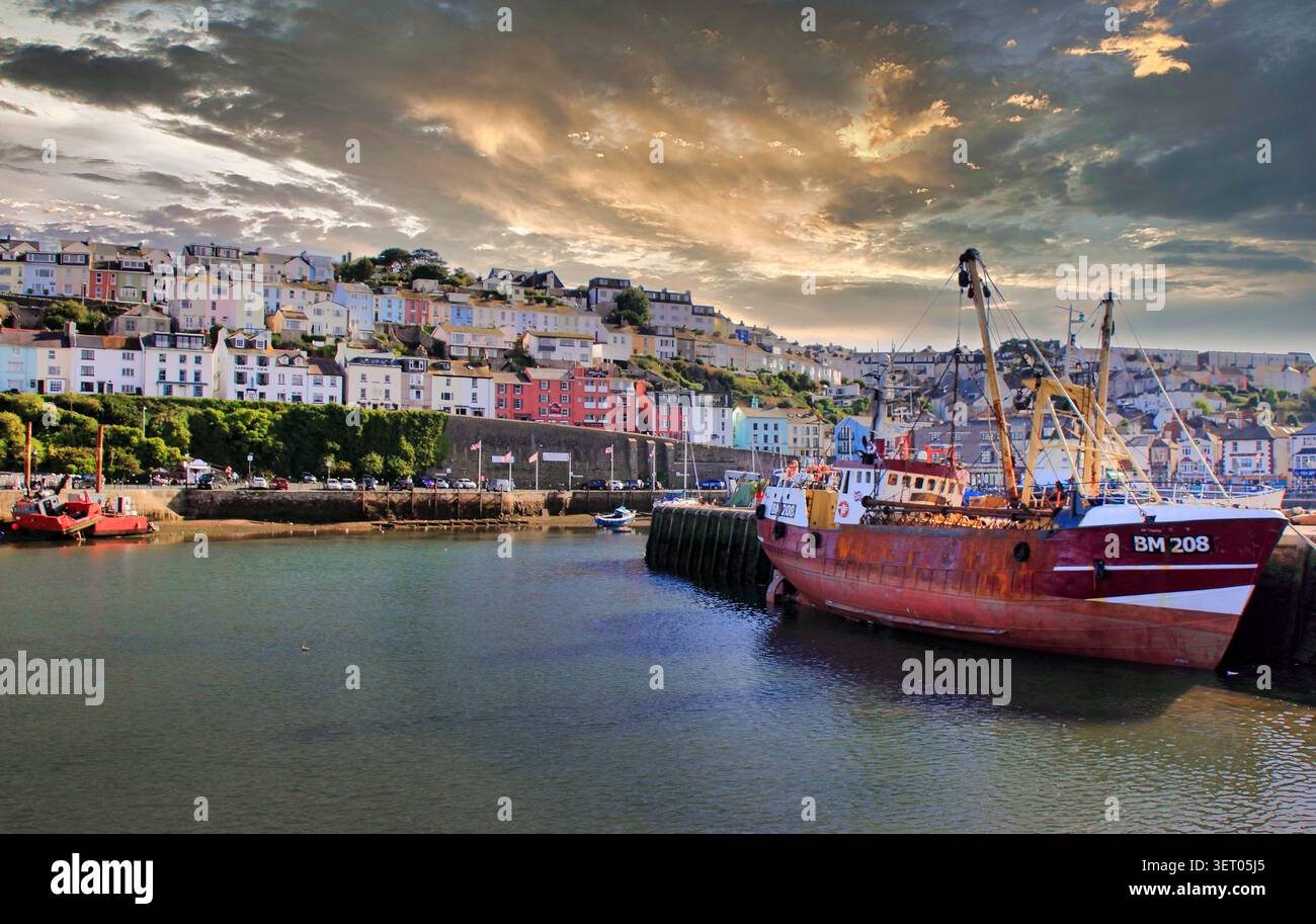 Un Trawler basé à Brixham attaché au Quayside dans son port d'attache et tous les chalets colorés donnant sur la scène, Torbay, South Devon, Southwest Eng Banque D'Images