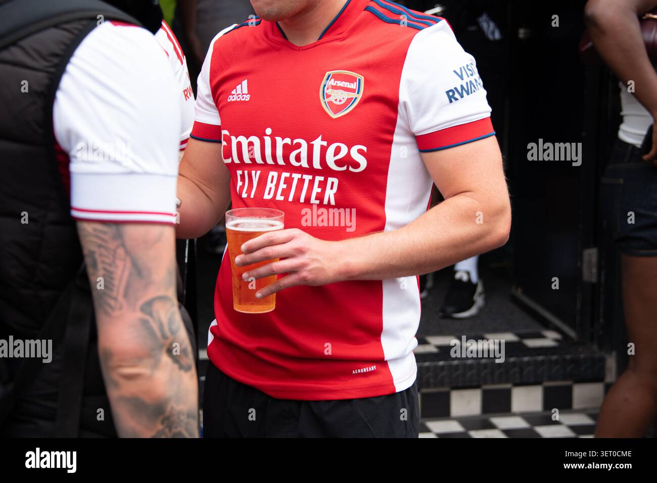 Un fan du club de football d'Arsenal tenant une tasse de bière Banque D'Images