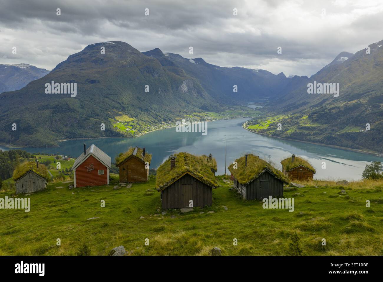 Vue aérienne de la ferme historique de montagne de Rakssetra avec des cabanes traditionnelles au toit en herbe surplombant le Nordfjord et les montagnes spectaculaires de Stryn Mun Banque D'Images