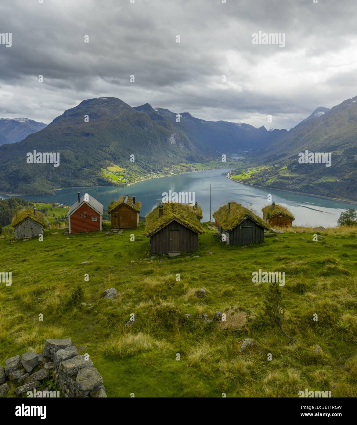 Vue aérienne de la ferme historique de montagne de Rakssetra avec des cabanes traditionnelles en bois au toit d'herbe surplombant les eaux bleues profondes du Nordfjord, Str Banque D'Images