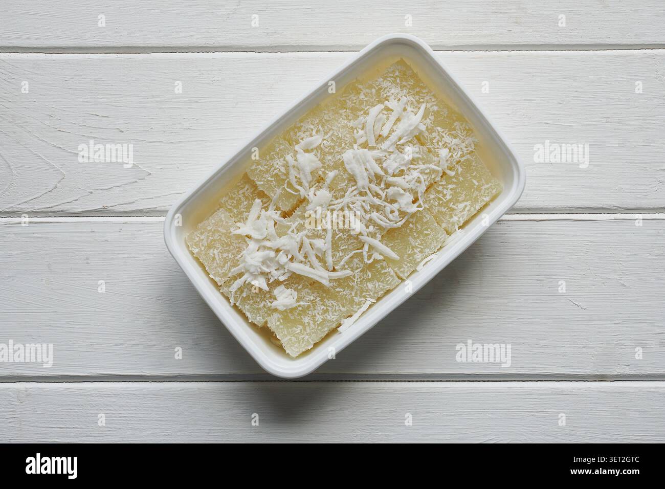 gâteau doux au manioc thaïlandais ou pudding au manioc avec copeaux de noix de coco dans un récipient en plastique du marché alimentaire de rue Banque D'Images