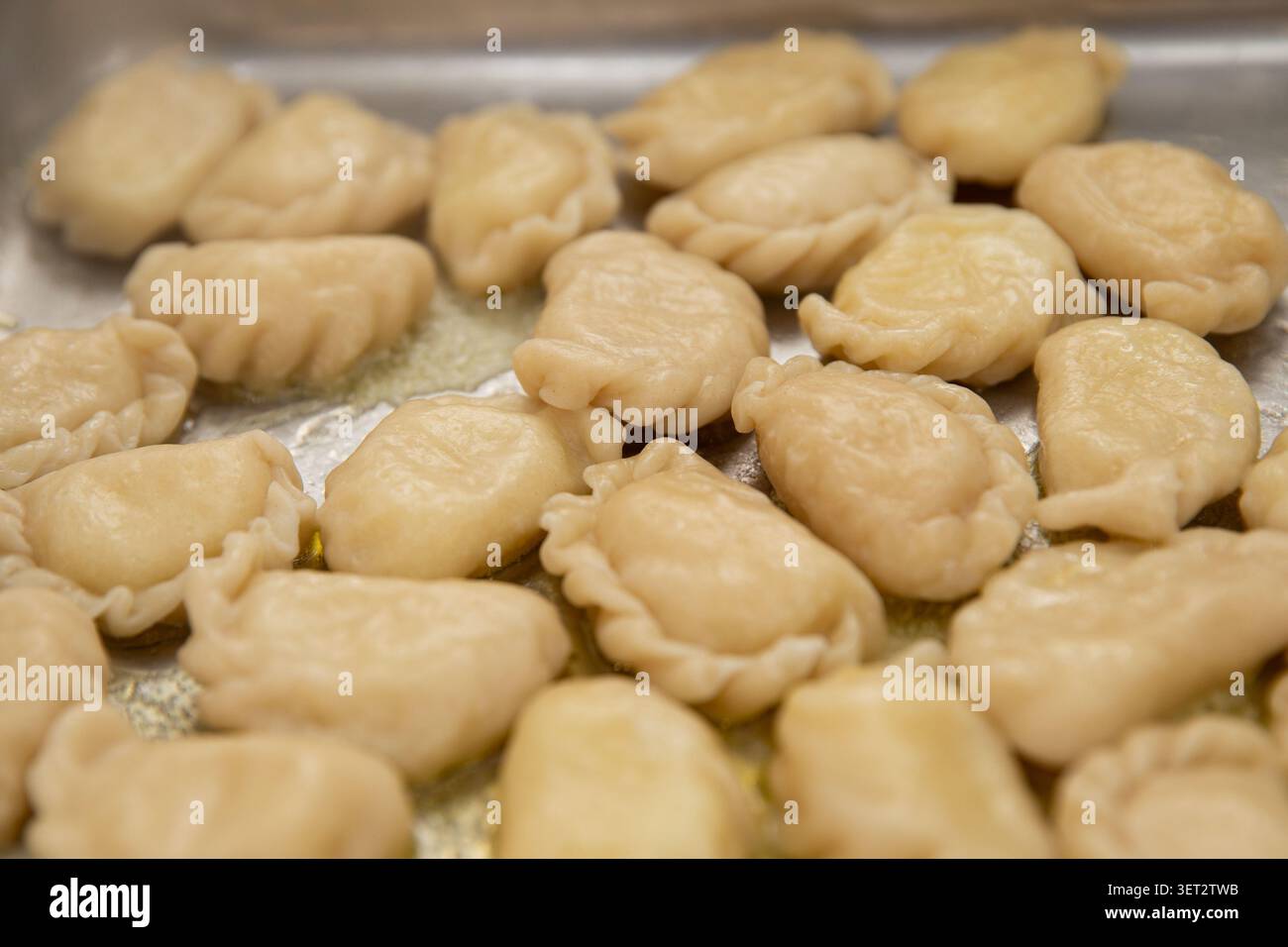 Boulettes traditionnelles ukrainiennes varenyky avec beurre sur un plateau en métal, vue de dessus en gros plan Banque D'Images