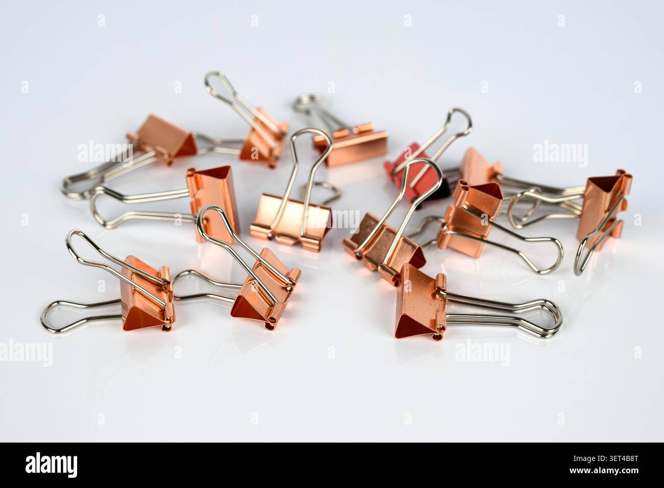 Clips de reliure en métal de couleur or rose, également connu sous le nom de clip de repli, pince à papier, clip de banquier, clip de repli, clip bobby, ou un fermoir Banque D'Images