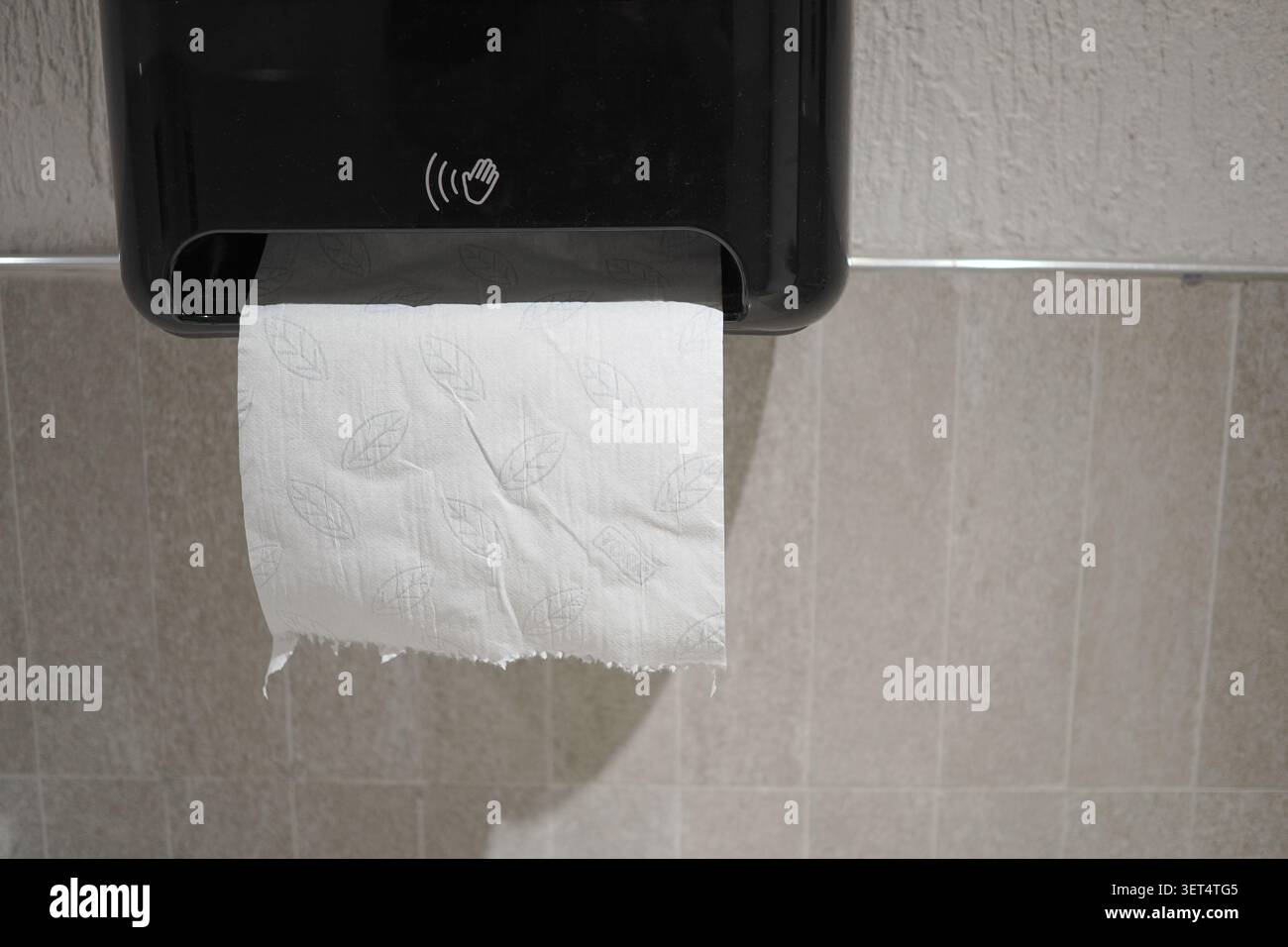 Sèche-mains distribuant du papier dans les toilettes d'un lieu public Banque D'Images