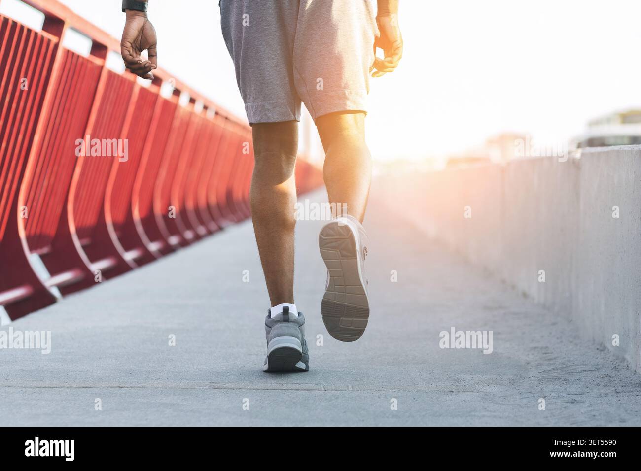 Image recadrée d'un homme africain sportif courant sur un pont Banque D'Images