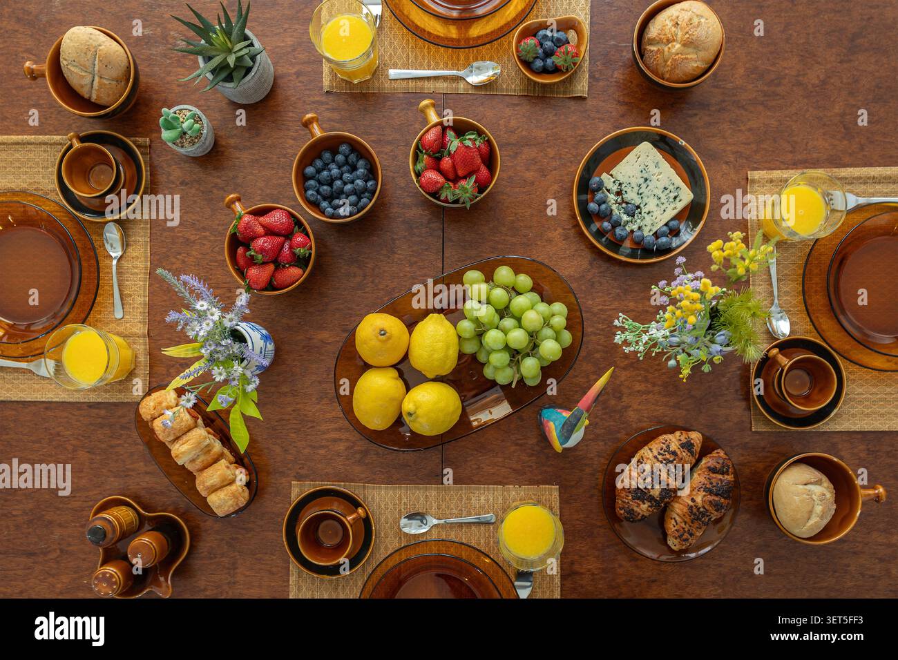 Vue de dessus de l'élégante table de brunch avec fruits frais, viennoiseries et jus d'orange Banque D'Images