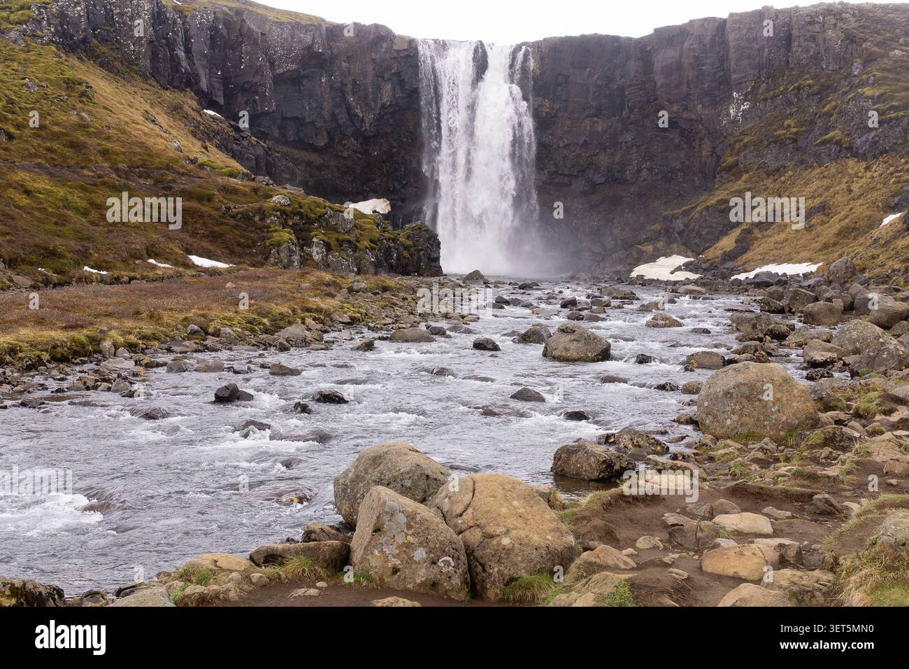 La cascade de Gufufoss dévale des falaises de basalte pour se jeter dans une rivière rocheuse près de Seyðisfjörður, dans l'est de l'Islande. Banque D'Images