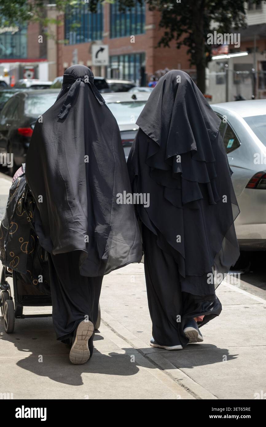 Des femmes musulmanes anonymes habillées modestement de vêtements noirs de longueur plancher. Dans la section Little Bangladesh de Jackson Heights, Queens, NY Banque D'Images