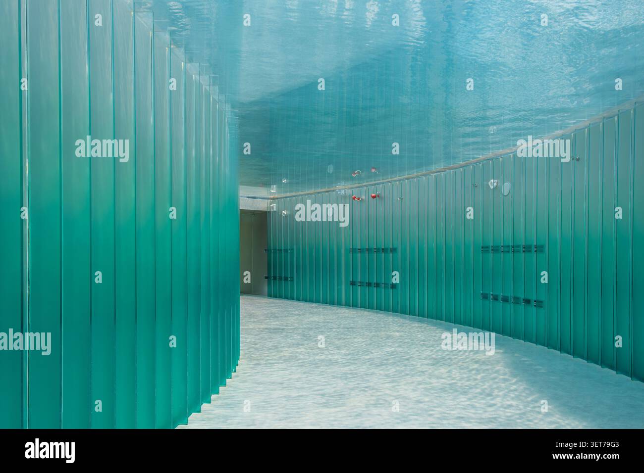 Couloir d'exposition immersif de style sous-marin avec murs en verre turquoise et surface réfléchissante de l'eau à Shanghai, en Chine. Architecture contemporaine Banque D'Images