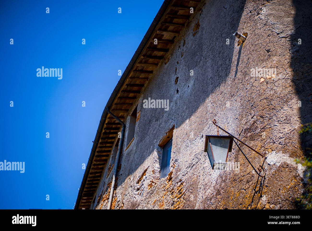 22-05-2023 Italie : lanterne en ferronnerie sur un mur de briques apparentes avec ciel bleu Banque D'Images