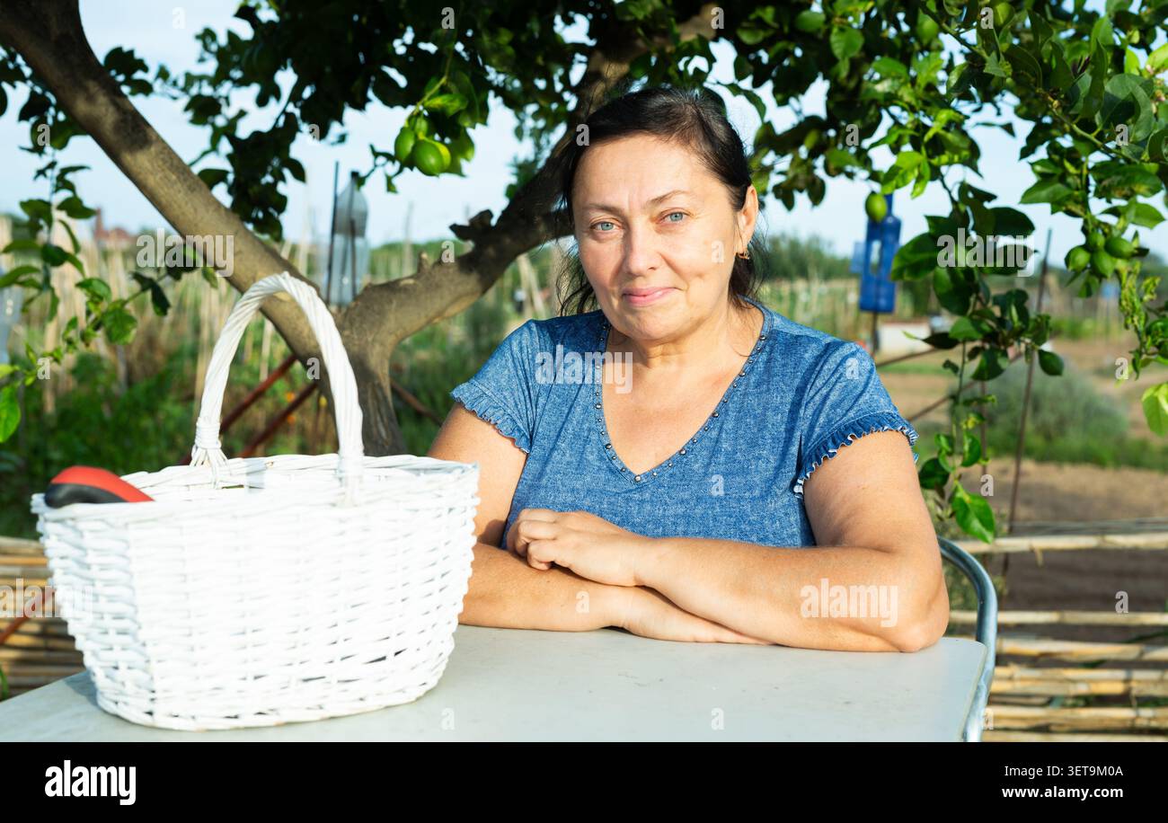 Portrait d'une femme adulte avec des outils de jardinage le jour d'été Banque D'Images
