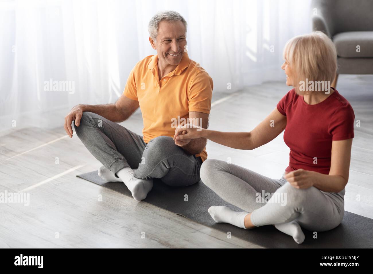 Heureux couple âgé caucasien pratiquant le yoga ensemble à la maison, concept de perte de poids Banque D'Images