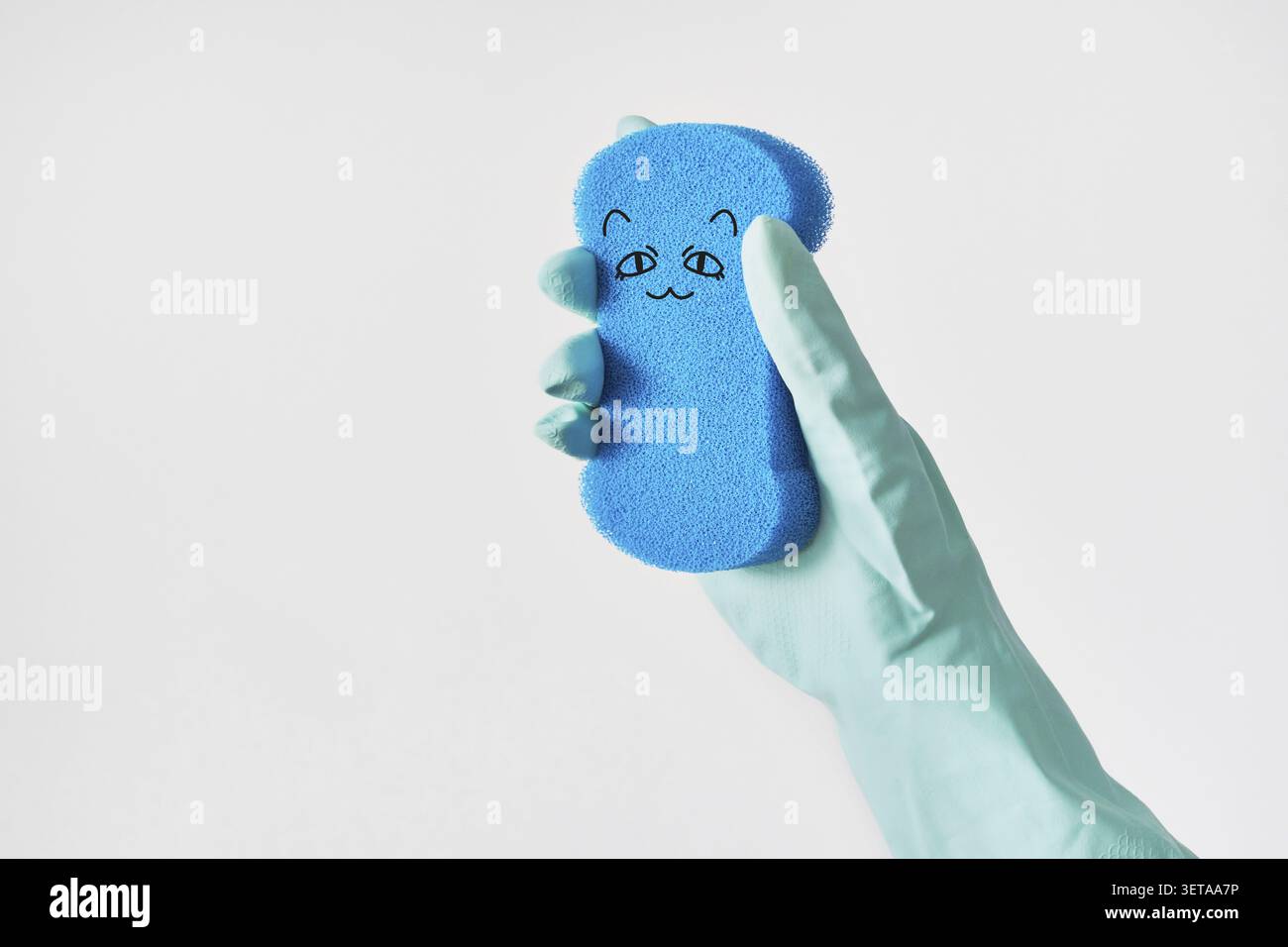 Gant de protection portable avec éponge bleue et visage de chat mignon dans la conception de bande dessinée Banque D'Images
