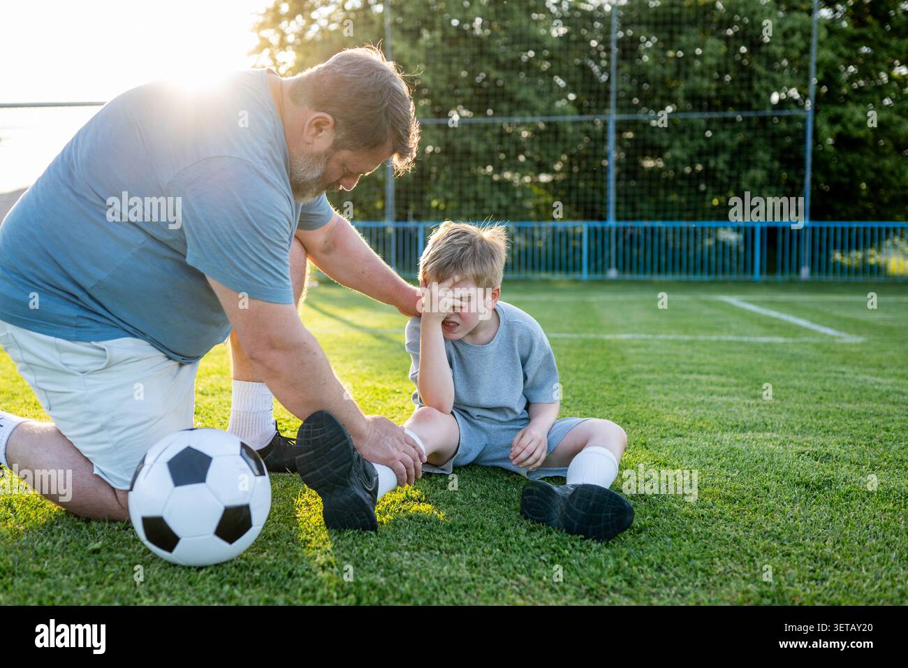 Garçon ayant un petit accident pendant l'entraînement de football. Banque D'Images