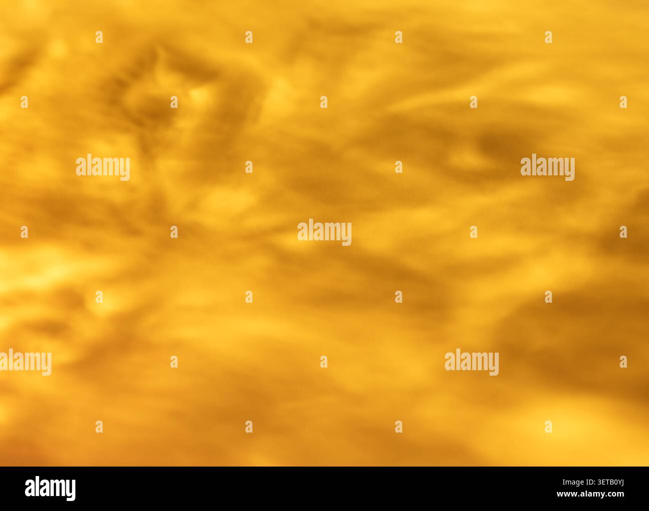 Macro de texture en verre ambré doré avec surface translucide ondulée pour fond abstrait chaud Banque D'Images