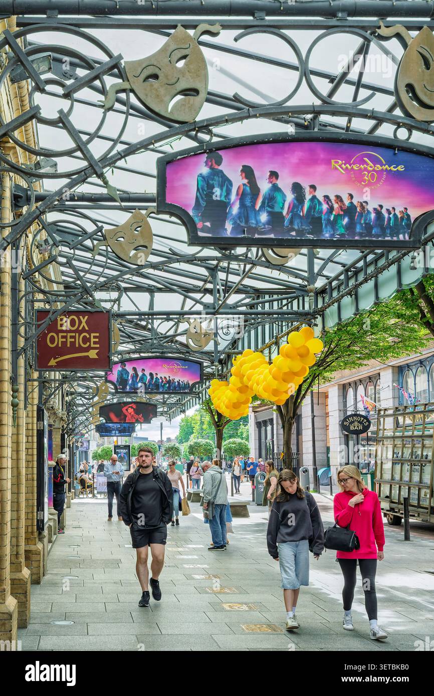 Piétons marchant sous une verrière décorative en fer avec le panneau d'affichage Riverdance 30 au Gaiety Theatre sur South King Street à Dublin en Irlande Banque D'Images