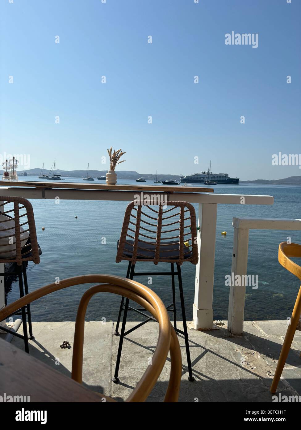 Café en front de la mer avec vue sur le port à Adamantas, Milos, Cyclades, Grèce. - Image de stock capturée avec un smartphone