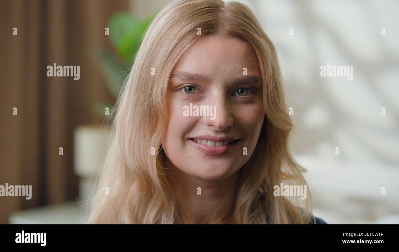 Portrait heureux visage féminin caucasien souriant avec un sourire dentaire sain à la maison. Gros plan attrayant femme européenne femme fille regardant la caméra Banque D'Images