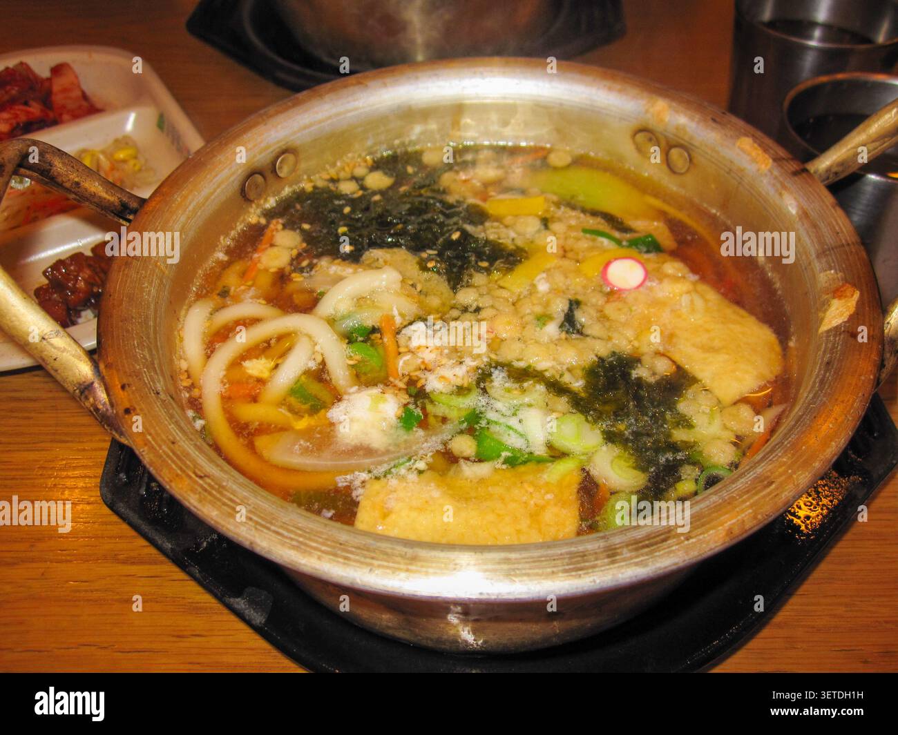 Soupe de nouilles coréenne cuisinée dans une casserole en laiton traditionnelle Banque D'Images