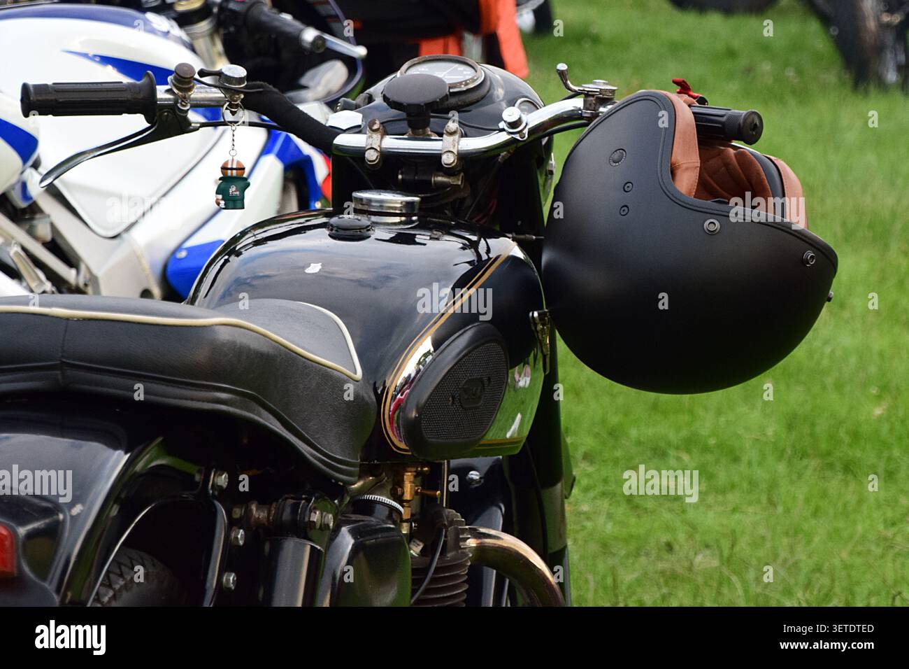 Royston, Hertfordshire, Angleterre - 17 juin 2026 : casque suspendu à une moto classique au salon Royston & District Motorcycle Club Banque D'Images