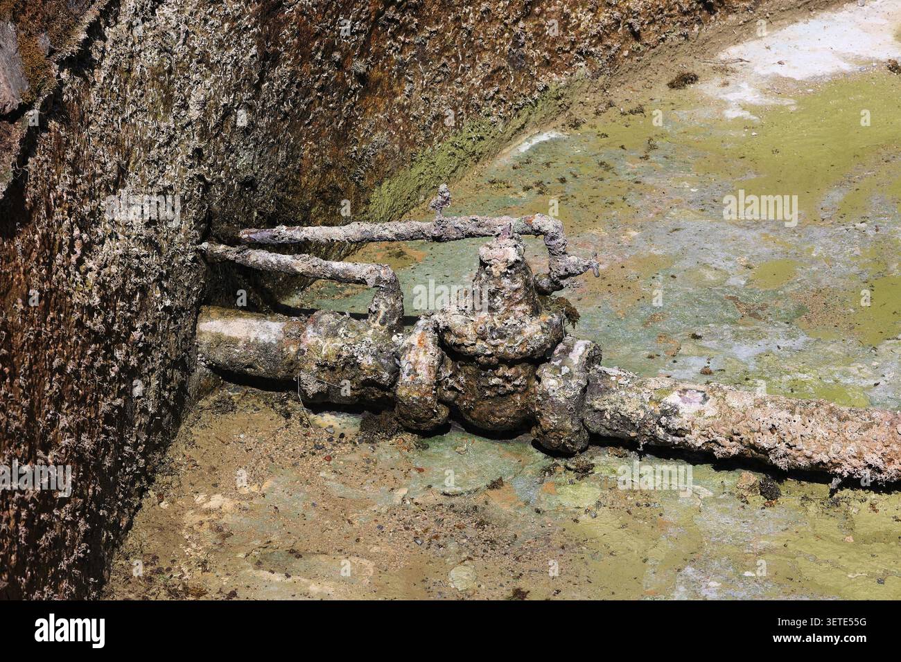 Tuyau d'eau sale au fond d'une fontaine vide. Banque D'Images