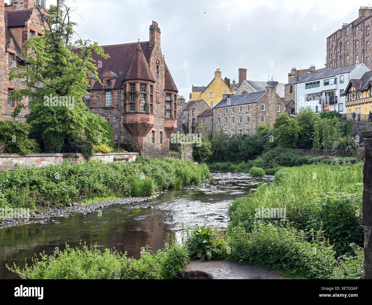Bâtiment en grès rouge Well court et végétation luxuriante le long de l'eau de la rivière Leith à Dean Village, Édimbourg, Écosse. Banque D'Images