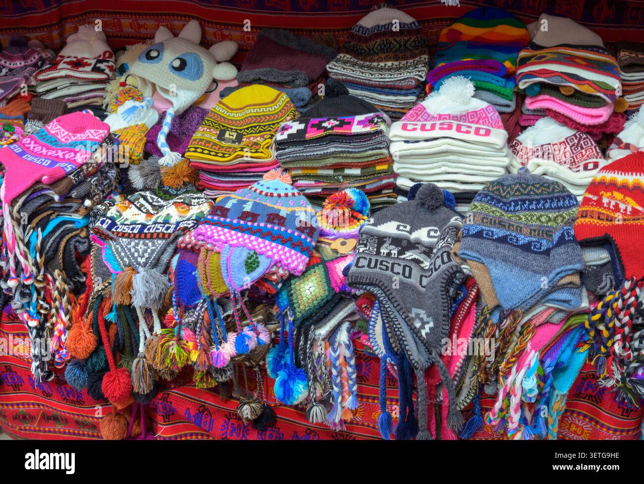 Bonnet en laine d'alpaga avec des motifs colorés traditionnels dans une boutique touristique du centre historique de Cusco, Pérou. Banque D'Images