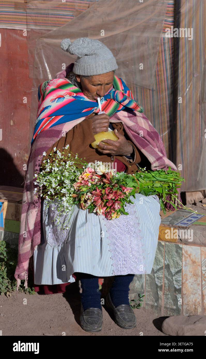 Une dame péruvienne consommant la Harina de Chuño (boisson andine à base de fécule), un petit déjeuner liquide traditionnel vendu dans la rue, Cusco, Pérou. Banque D'Images
