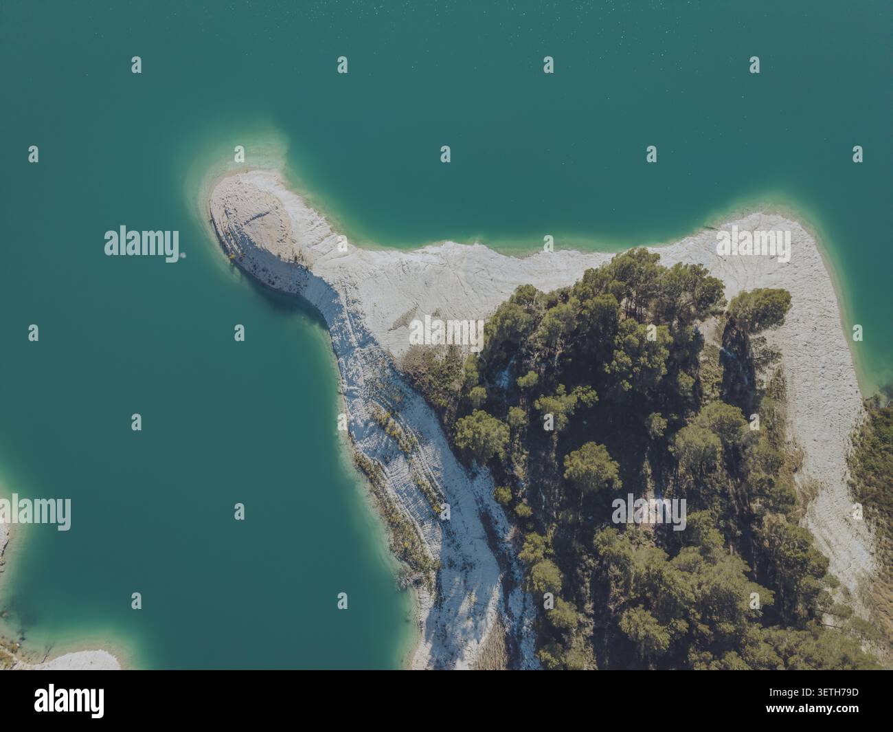 Vue aérienne des eaux turquoises du réservoir Guadalest, avec une péninsule rocheuse couverte de pins s'étendant dans l'eau, Alicante, Valen Banque D'Images