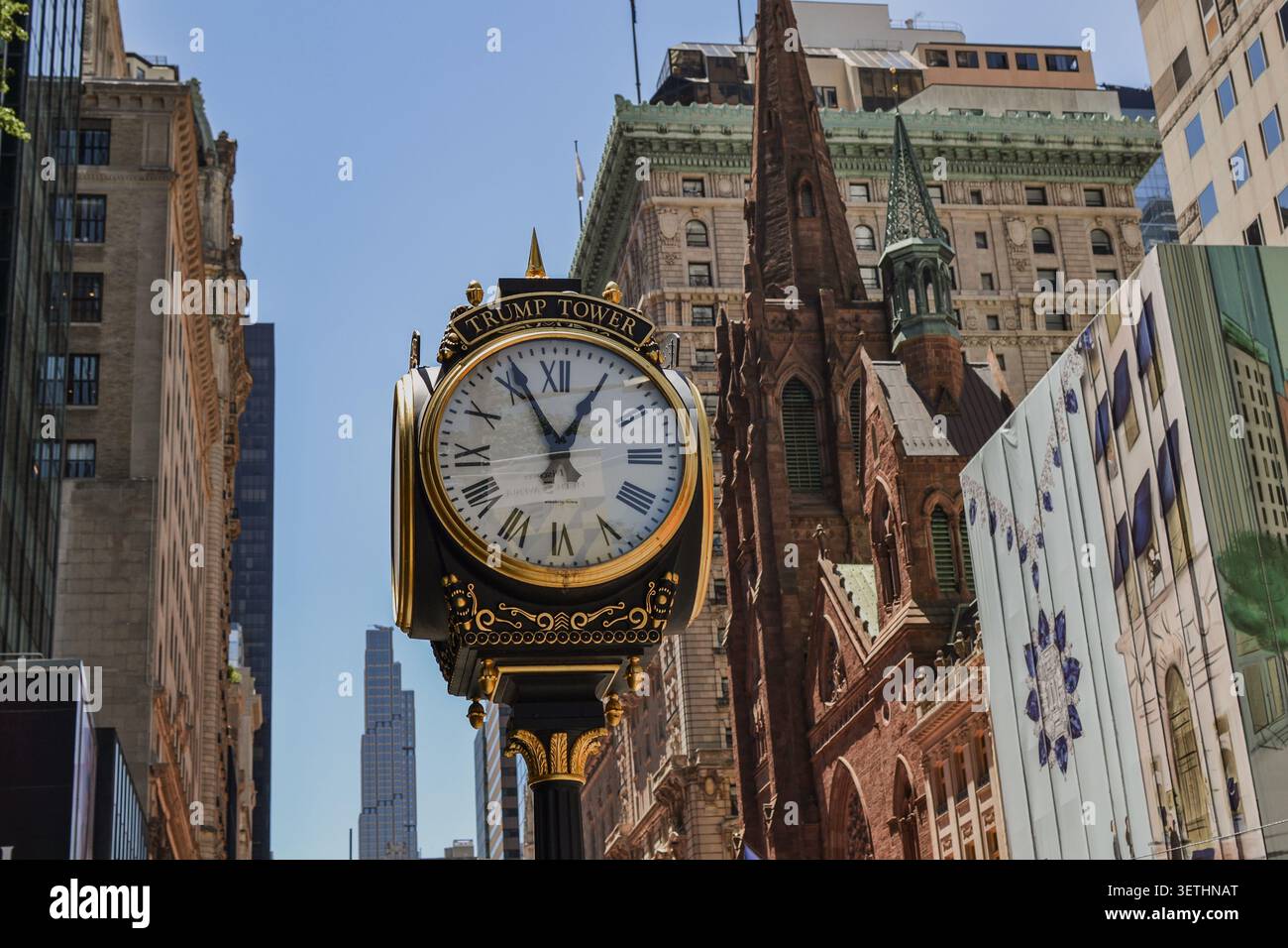 New York City, États-Unis – 16 juin 2026 : horloge de trottoir ornée de la Trump Tower avec l'église presbytérienne de la Cinquième Avenue en arrière-plan. Banque D'Images