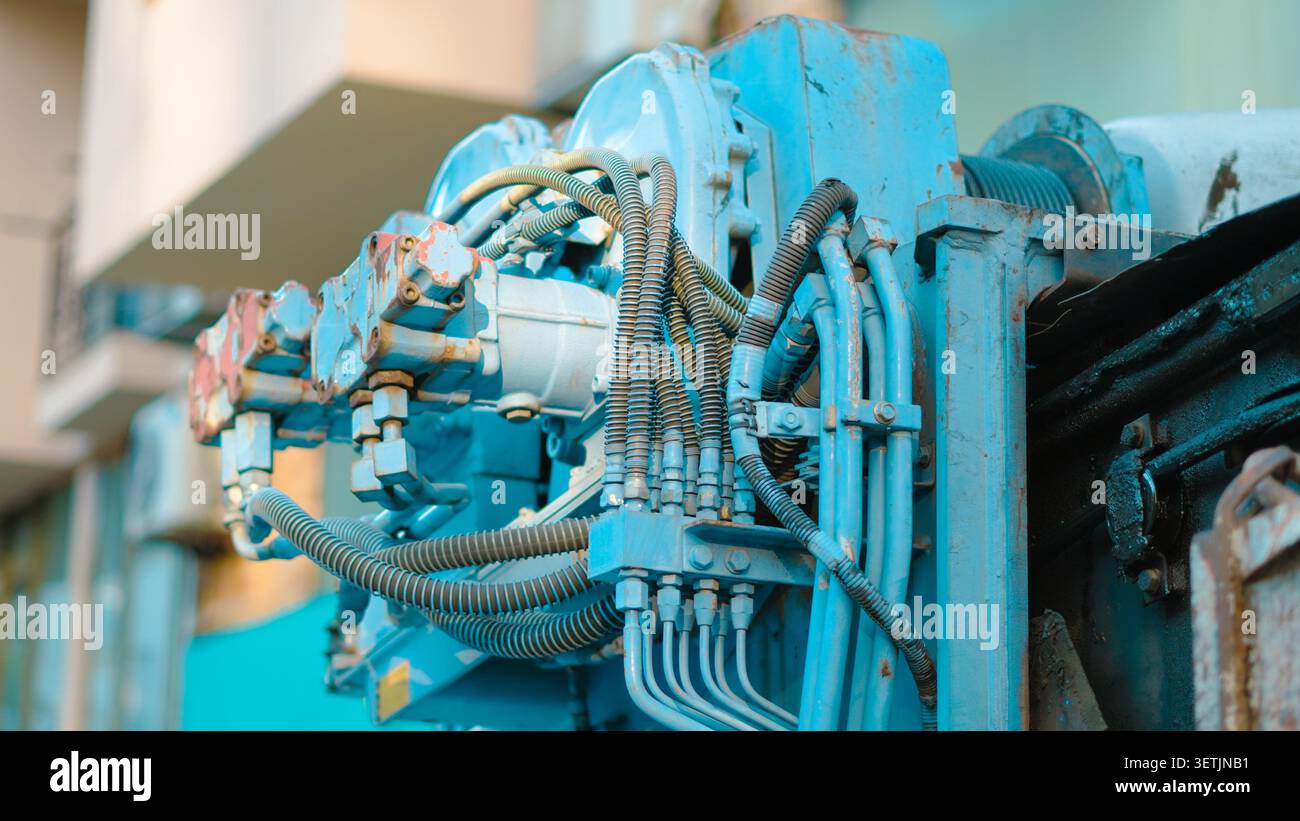 Mécanisme de machinerie industrielle avec des composants et des tuyaux hydrauliques bleus Banque D'Images