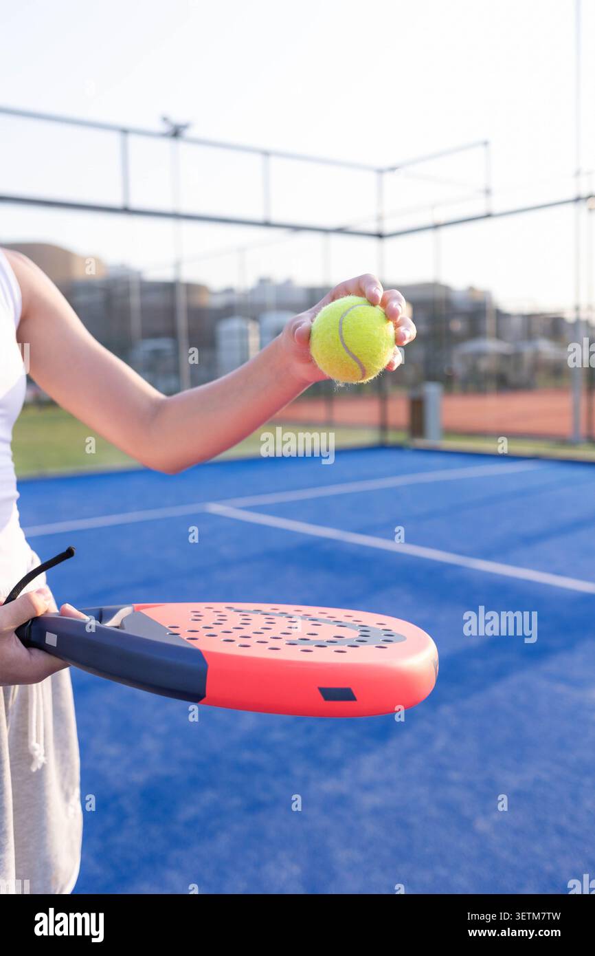 Servir mouvement avec paddle et balle sur terrain bleu extérieur pendant la séance d'entraînement ensoleillée Banque D'Images