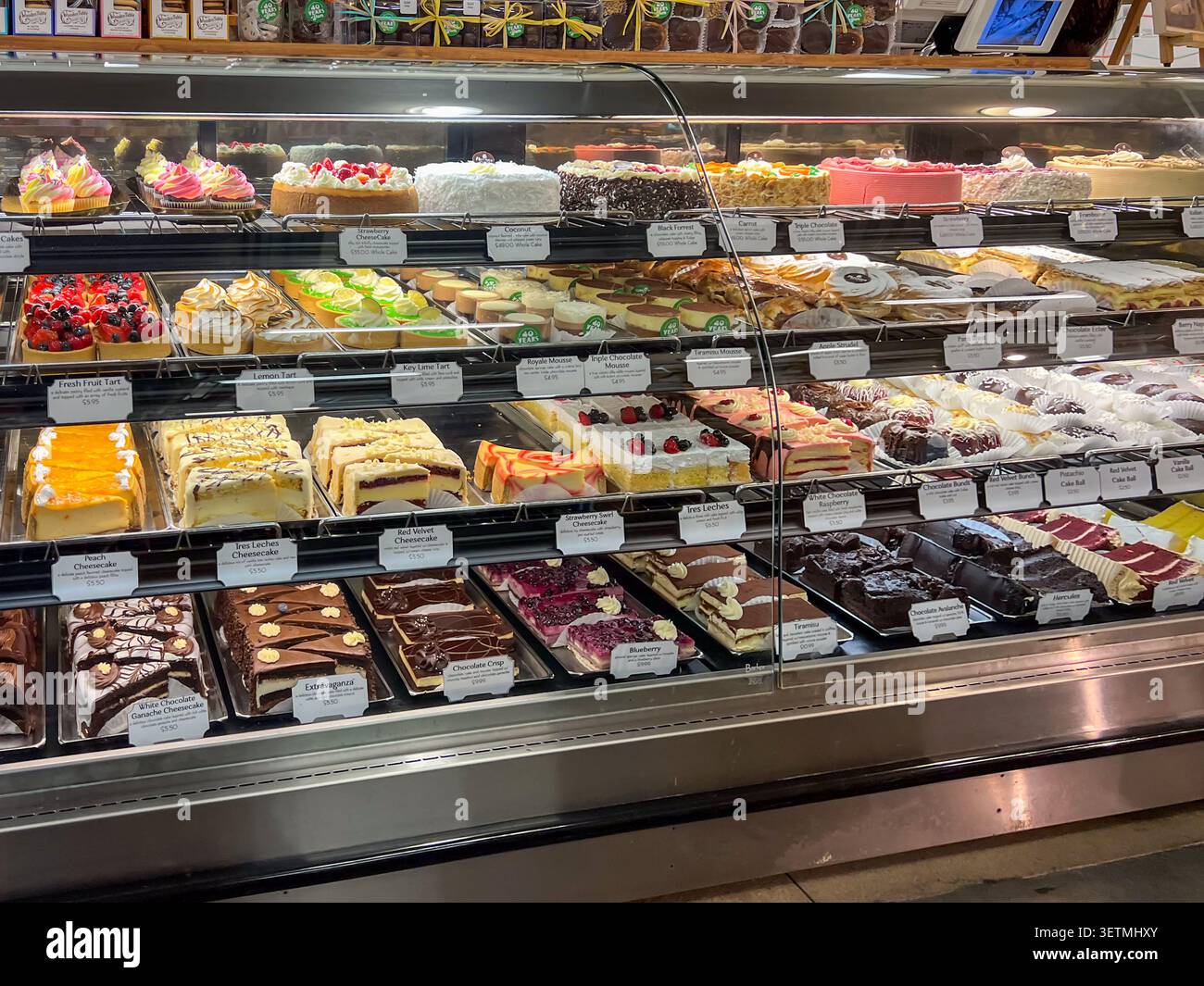 Une grande variété de desserts importés et artisanaux, y compris de nombreux gâteaux et pâtisseries dans une casserole réfrigérée dans un supermarché. Texas, États-Unis Banque D'Images