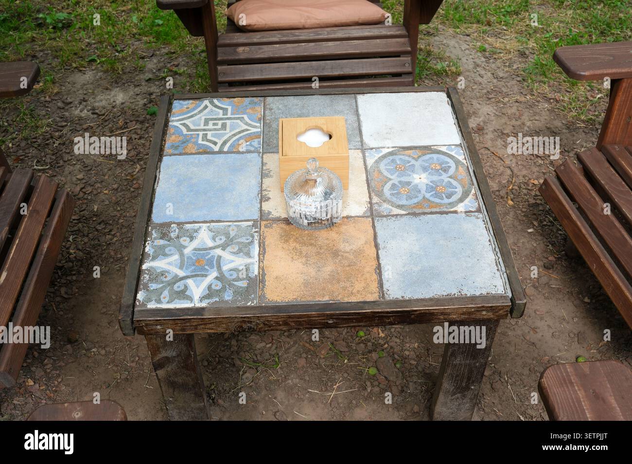 Charmant espace extérieur dispose d'une table en mosaïque colorée entourée de chaises en bois. Banque D'Images