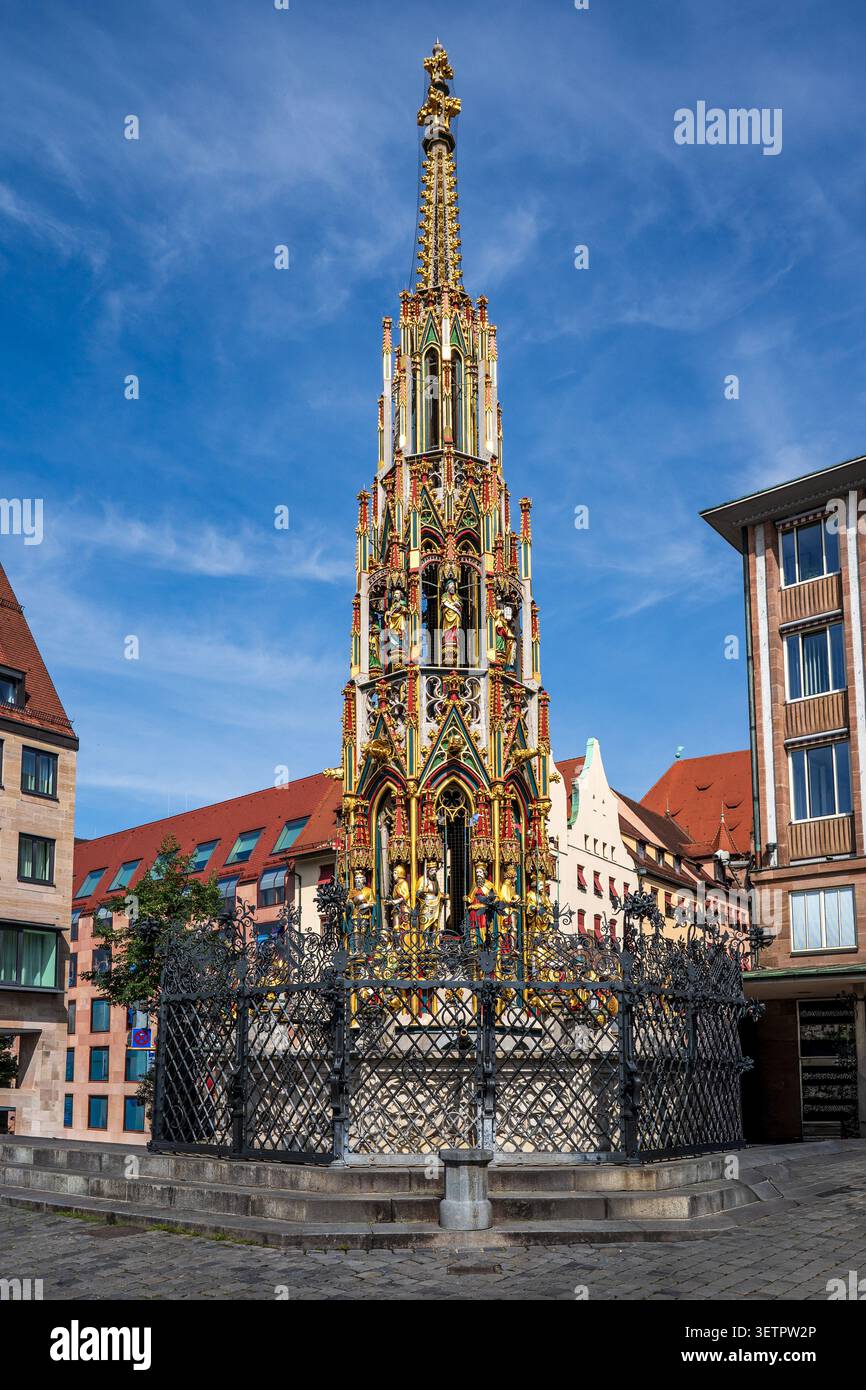 Superbe vue verticale de la célèbre fontaine Schöner Brunnen à Nuremberg. La flèche gothique, riche de statues dorées et de détails colorés, se dresse ma Banque D'Images